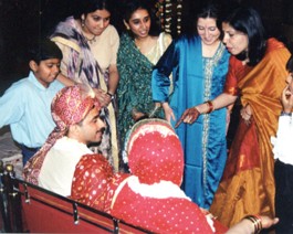 Shoe-Money-Barter This picture depicts the 'shoe negotiations'. Girls from the brides family hide the Grooms shoes while the ceremony is in progress. Afterwards, they 'sell' the...